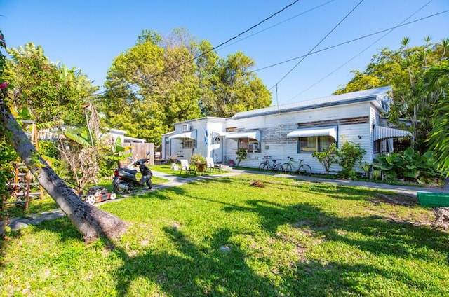 rear view of property featuring a yard