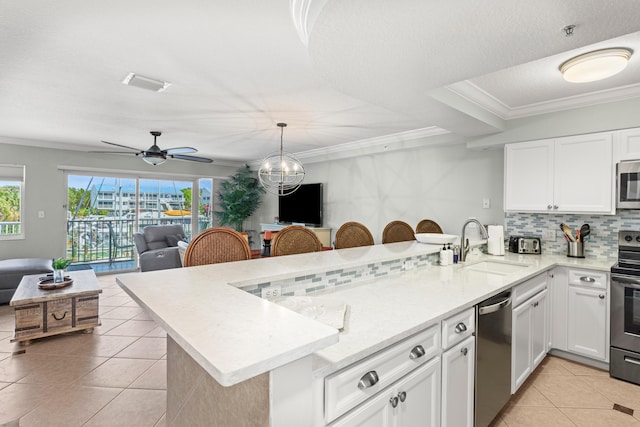 95 Coco Plum Dr Unit 5D, Marathon, FL 33050 - kitchen featuring appliances with stainless steel finishes, a sink, a peninsula, light tile patterned flooring, and open floor plan