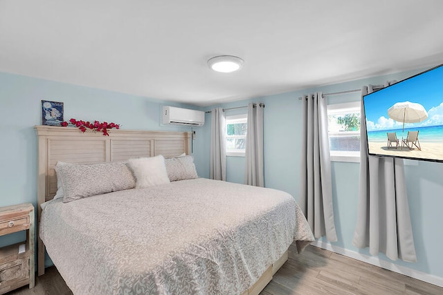 bedroom featuring a wall mounted air conditioner and wood-type flooring