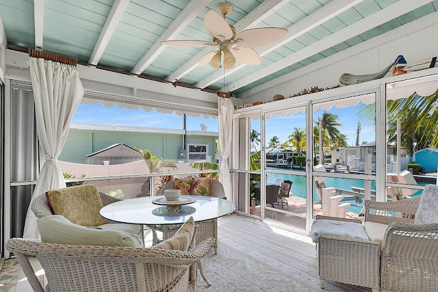 sunroom with ceiling fan and lofted ceiling with beams