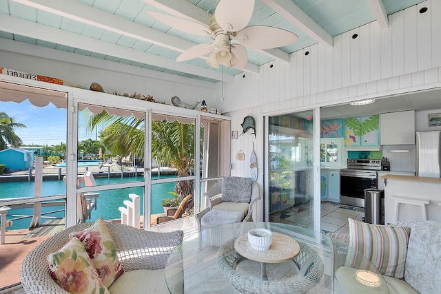 sunroom / solarium featuring a water view, vaulted ceiling with beams, and ceiling fan