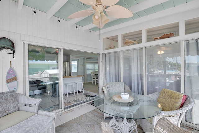 sunroom with ceiling fan and lofted ceiling with beams