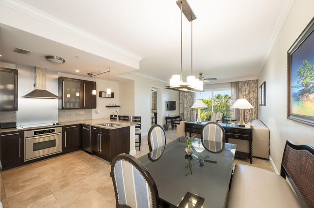 dining area featuring sink, crown molding, and ceiling fan