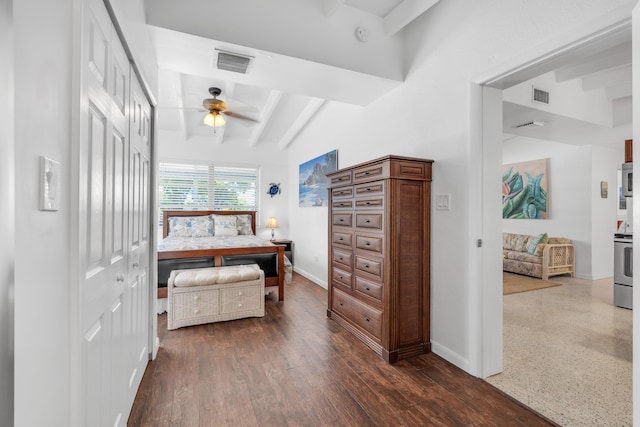 bedroom with ceiling fan, dark hardwood / wood-style floors, beam ceiling, and a closet