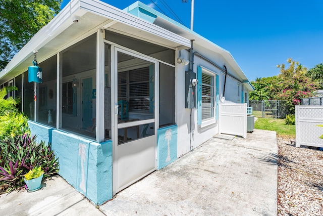 view of property exterior with a sunroom