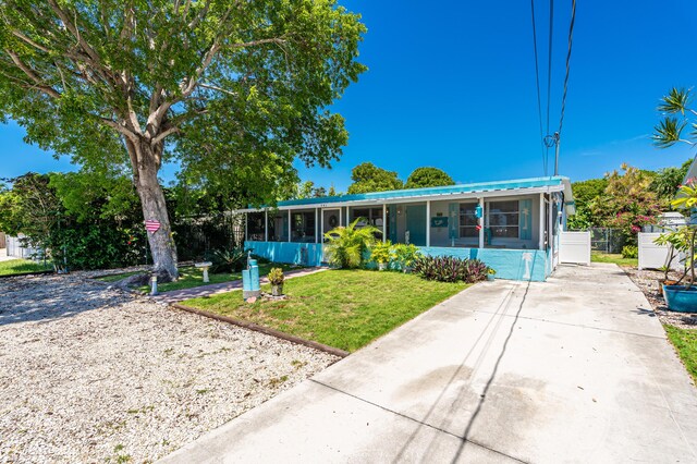 view of front of house featuring a front yard and a sunroom