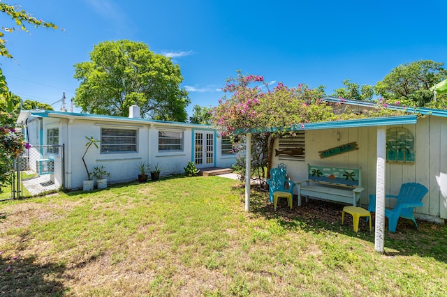 back of property with a yard and french doors