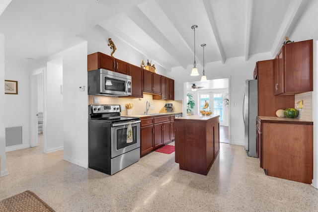 kitchen featuring decorative light fixtures, sink, a center island, stainless steel appliances, and beam ceiling