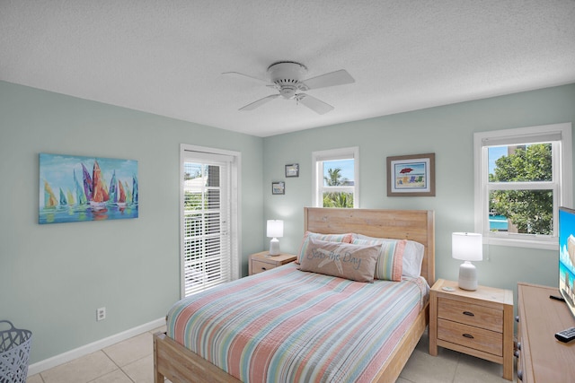 tiled bedroom featuring ceiling fan, multiple windows, and a textured ceiling