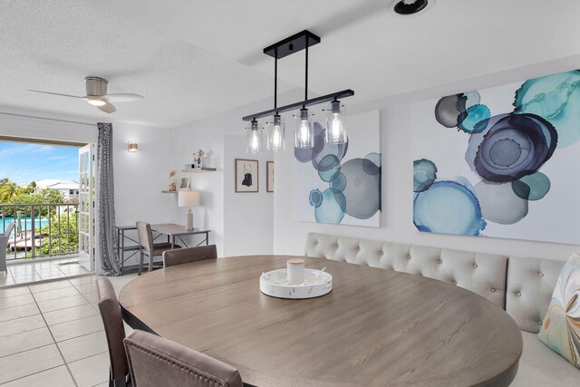 tiled dining room featuring ceiling fan and a textured ceiling