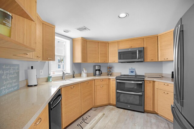 kitchen with light hardwood / wood-style floors, appliances with stainless steel finishes, light brown cabinetry, and sink