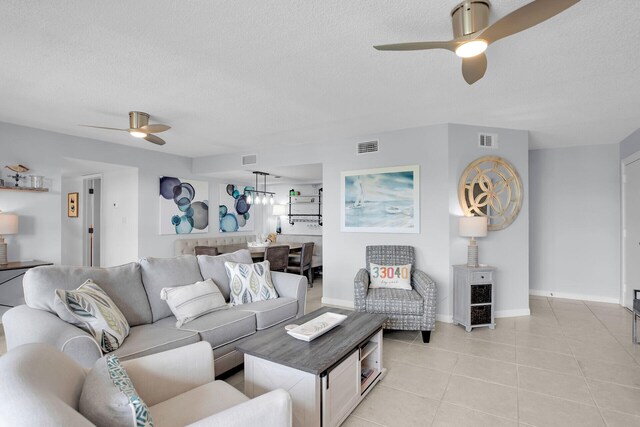 tiled living room featuring a textured ceiling and ceiling fan