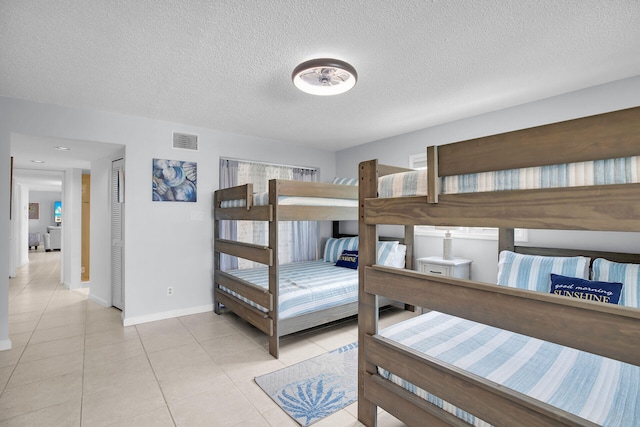 bedroom featuring light tile patterned floors and a textured ceiling