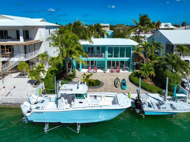 back of house with a water view and a patio area