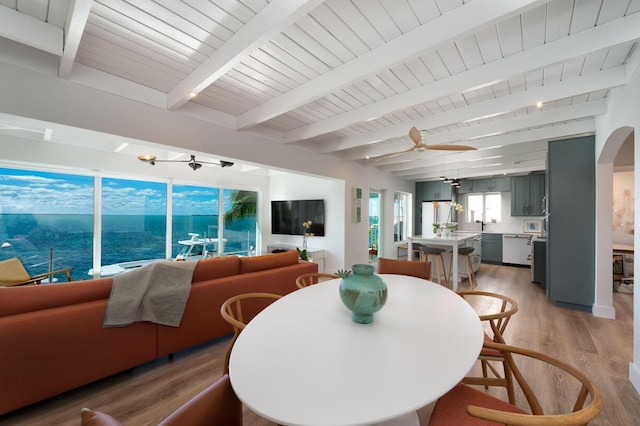 dining area with ceiling fan, beam ceiling, light hardwood / wood-style floors, and wooden ceiling