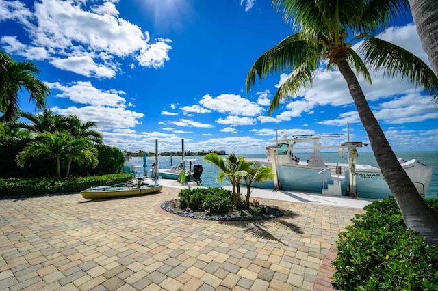 view of patio featuring a water view and a dock