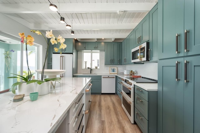 kitchen with white appliances, light stone countertops, light hardwood / wood-style floors, green cabinetry, and beamed ceiling