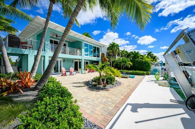 rear view of property with a patio and a balcony