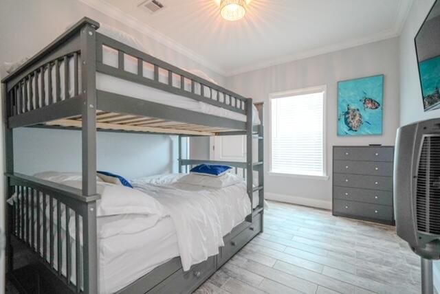 bedroom featuring crown molding and light wood-type flooring