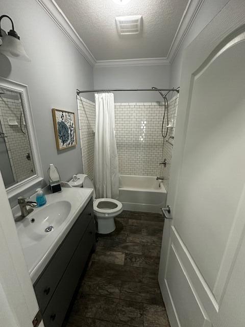 full bathroom with ornamental molding, vanity, toilet, shower / bath combo, and a textured ceiling