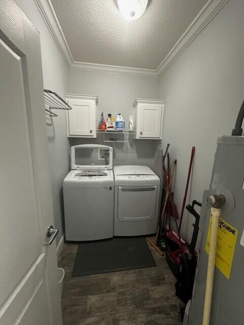 washroom with cabinets, ornamental molding, independent washer and dryer, electric water heater, and a textured ceiling