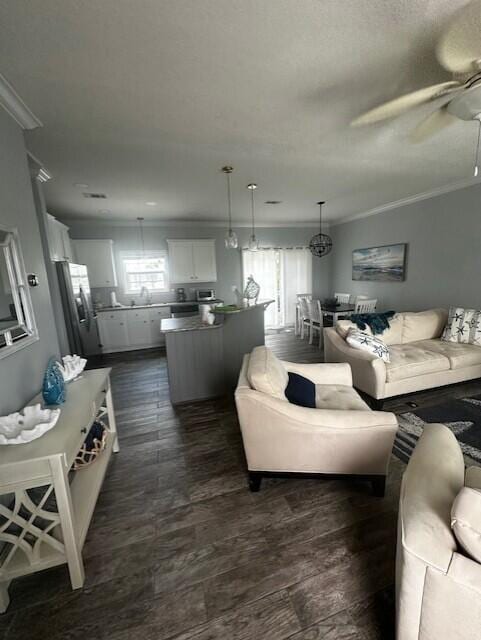 living room featuring dark wood-type flooring, ceiling fan, and ornamental molding