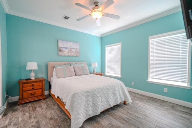 bedroom featuring crown molding, wood-type flooring, and ceiling fan