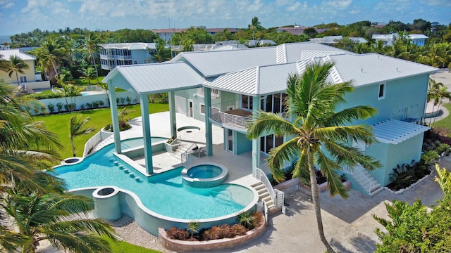 back of house featuring a pool with hot tub, a patio, and a lawn