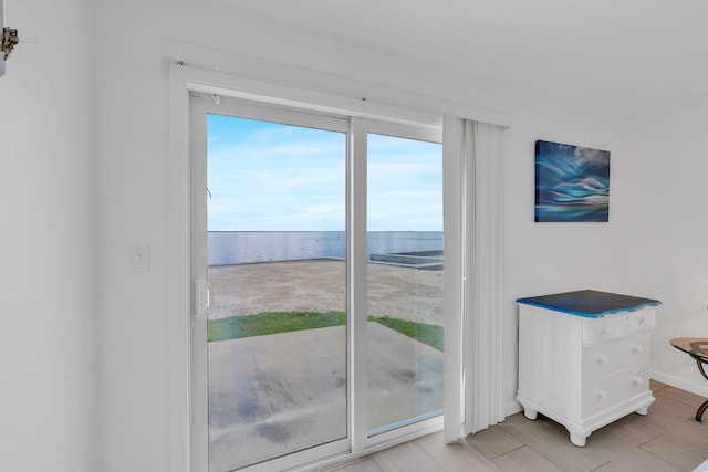 doorway to outside featuring a water view and light wood-type flooring