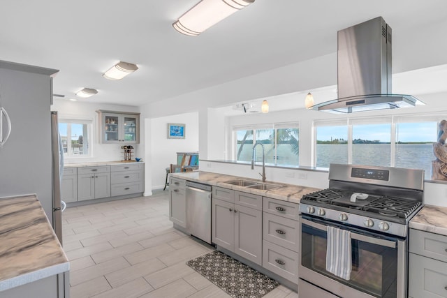 kitchen featuring sink, a water view, island range hood, gray cabinets, and stainless steel appliances