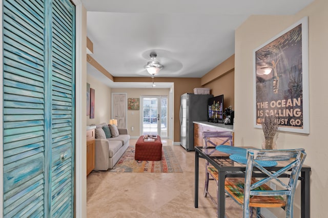 living room featuring ceiling fan and bar area