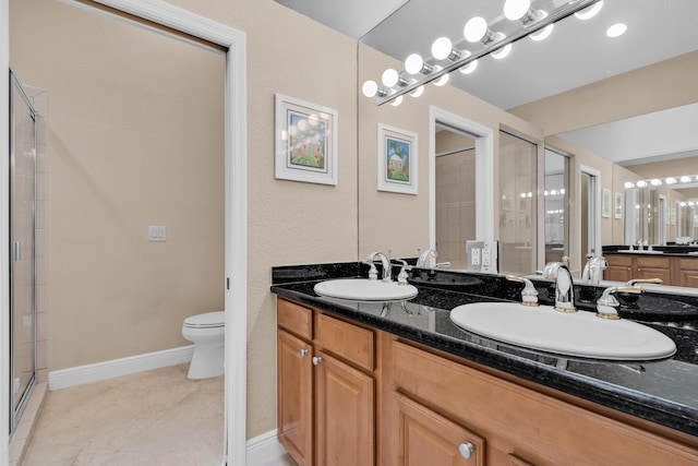 bathroom with vanity, tile patterned floors, a shower with door, and toilet