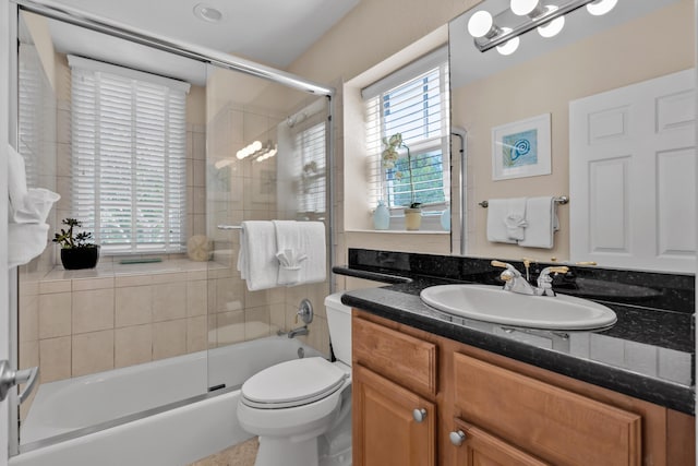 full bathroom with vanity, shower / bath combination with glass door, and toilet