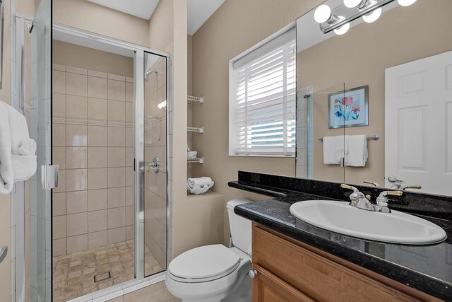 bathroom with vanity, a shower with shower door, and toilet