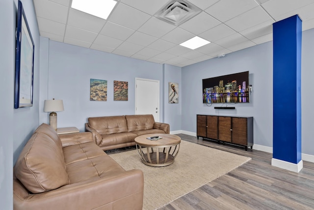 living room featuring hardwood / wood-style flooring and a drop ceiling