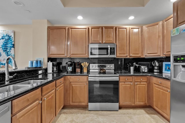 kitchen with tasteful backsplash, sink, dark stone counters, and appliances with stainless steel finishes