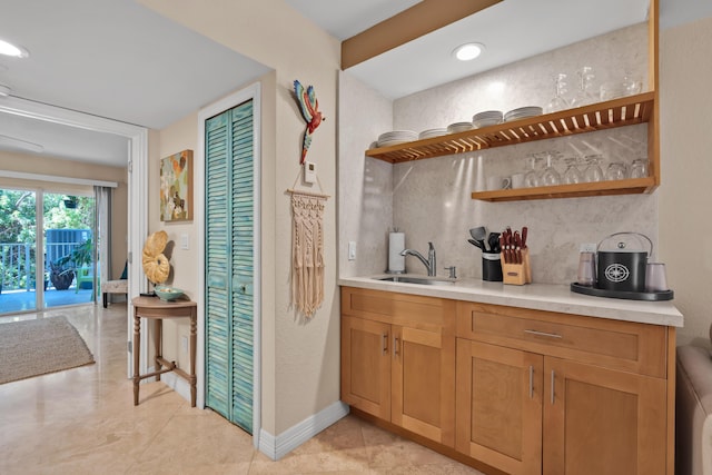 bar with tasteful backsplash, light tile patterned flooring, and sink