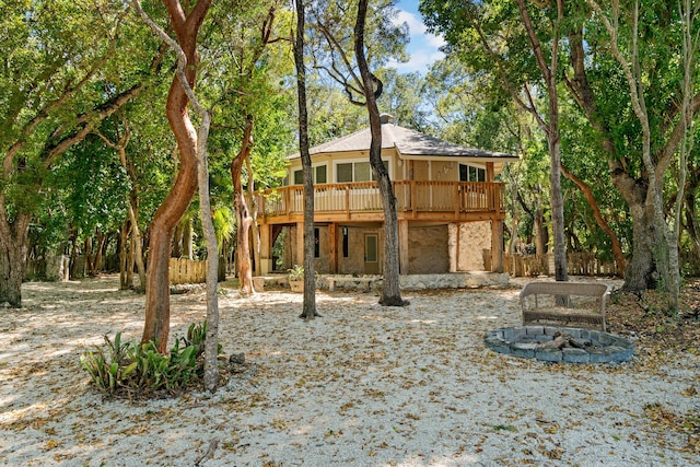 rear view of property with an outdoor fire pit, stucco siding, and a wooden deck