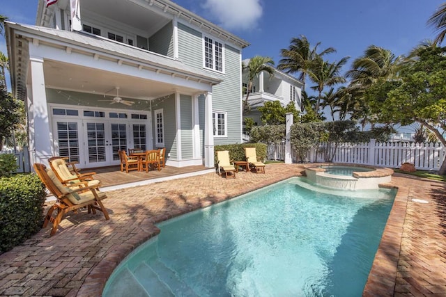 back of house with french doors, a pool with connected hot tub, a ceiling fan, a patio area, and fence