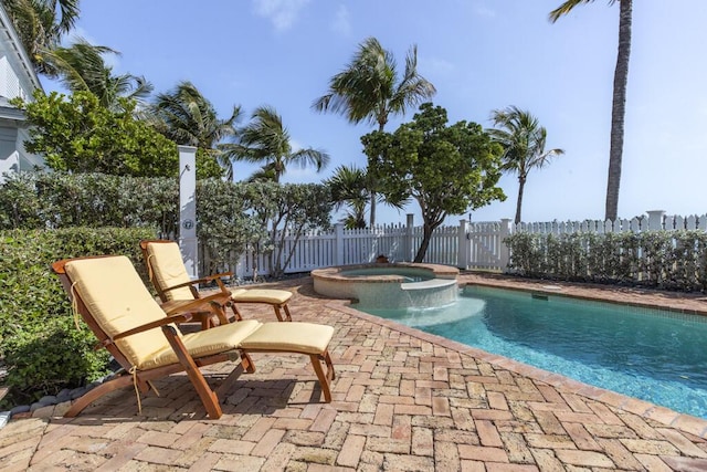 view of swimming pool featuring a patio, a fenced backyard, and a pool with connected hot tub