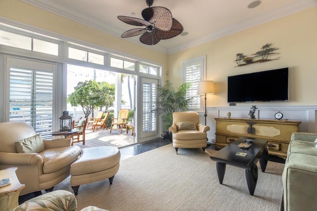 sitting room featuring ceiling fan, wainscoting, crown molding, and light tile patterned floors