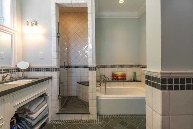 full bathroom with tile patterned flooring, vanity, tile walls, a bath, and crown molding