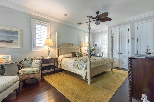 bedroom featuring dark wood-style floors, multiple windows, visible vents, and crown molding