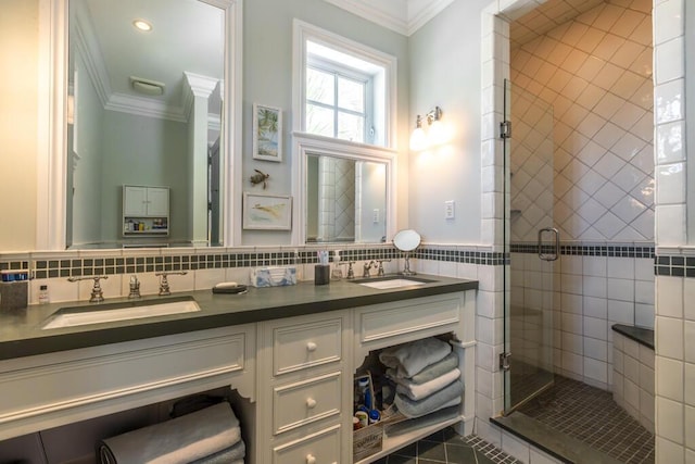 full bathroom featuring ornamental molding, a sink, and tile walls