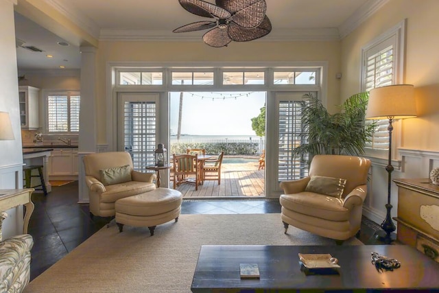 living area with a ceiling fan, tile patterned floors, visible vents, and crown molding