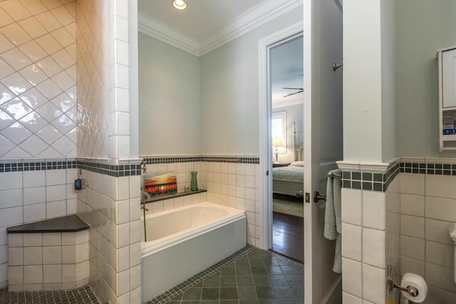 ensuite bathroom featuring tile walls, connected bathroom, tile patterned flooring, crown molding, and a bath