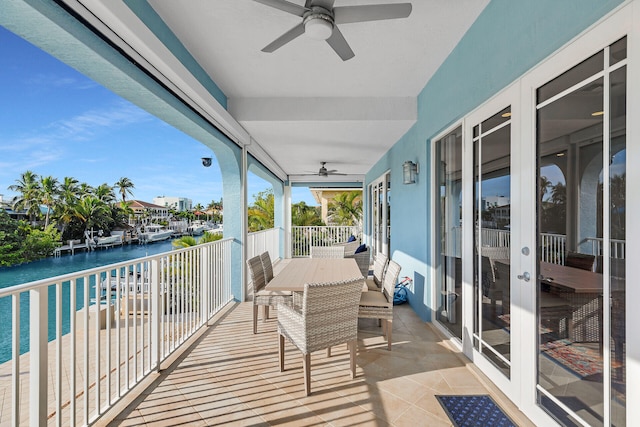 sunroom / solarium with a water view and ceiling fan