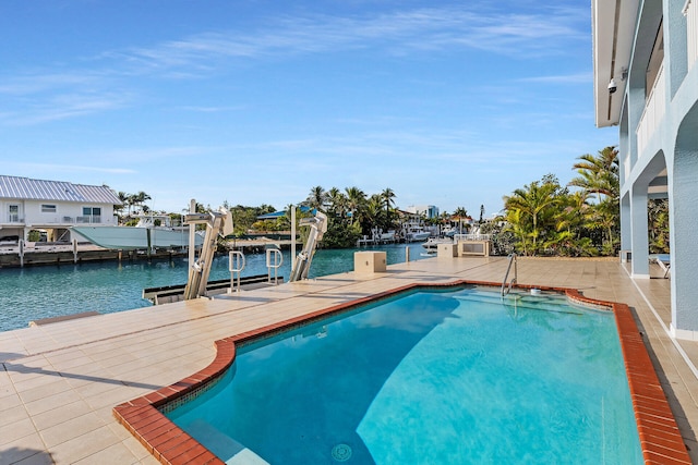 view of swimming pool featuring a water view and a dock