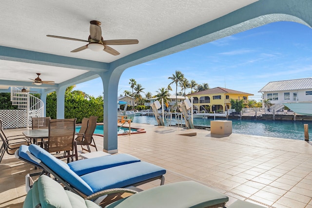 view of patio / terrace featuring a water view, ceiling fan, and pool water feature