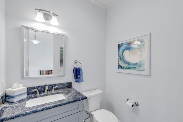 bathroom featuring crown molding, vanity, and toilet